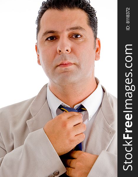 Flourishing businessman tying his tie and looking to camera