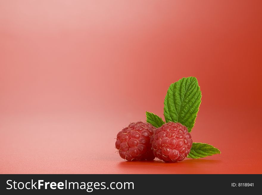 Close up view of nice fresh red raspberry on red back. Close up view of nice fresh red raspberry on red back