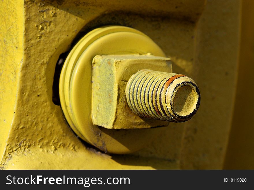 Close-up of large nut and bolt painted bright yellow. Close-up of large nut and bolt painted bright yellow.