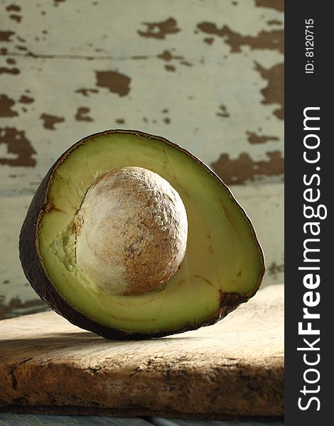 Sliced avocado, high vitamin E, big seed inside, on wooden plate. Sliced avocado, high vitamin E, big seed inside, on wooden plate.