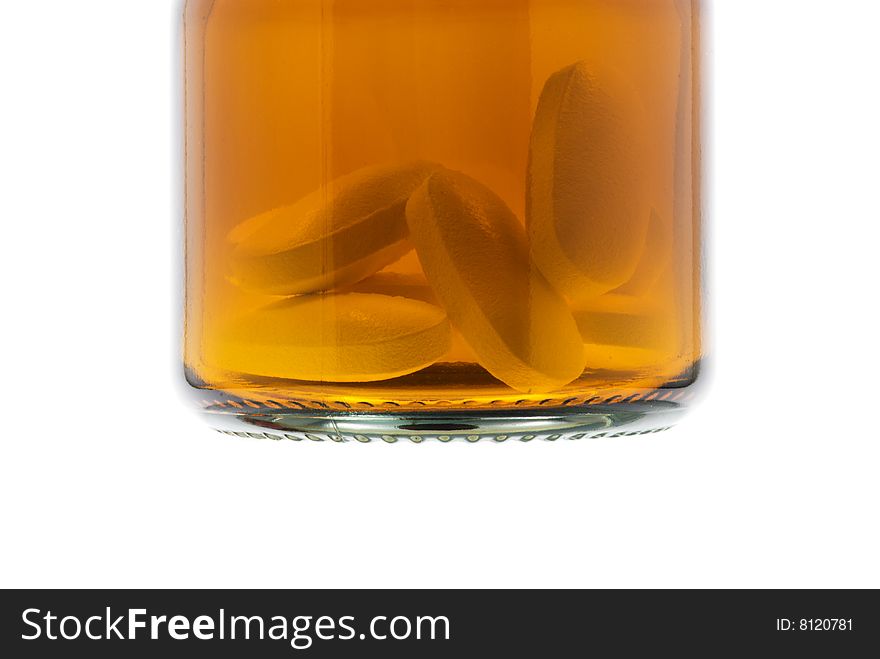 Transparent bottle with pills over white background