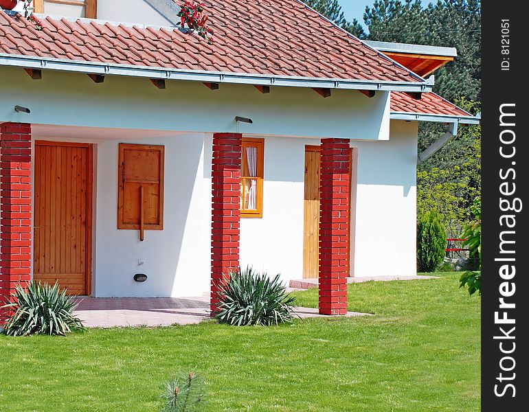 Fragment of small house tiled roof and garden. Fragment of small house tiled roof and garden