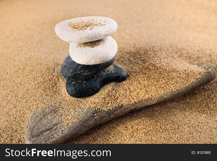 White and black sea pebble in a pile on sand