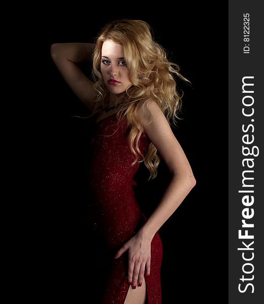 Beautiful blonde young lady in red dress on black background. Beautiful blonde young lady in red dress on black background