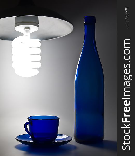 Blue empty transparent cup with plate and bottle. Blue empty transparent cup with plate and bottle