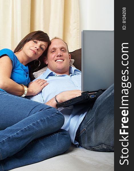 Young couple on the couch at home looking at the laptop!. Young couple on the couch at home looking at the laptop!