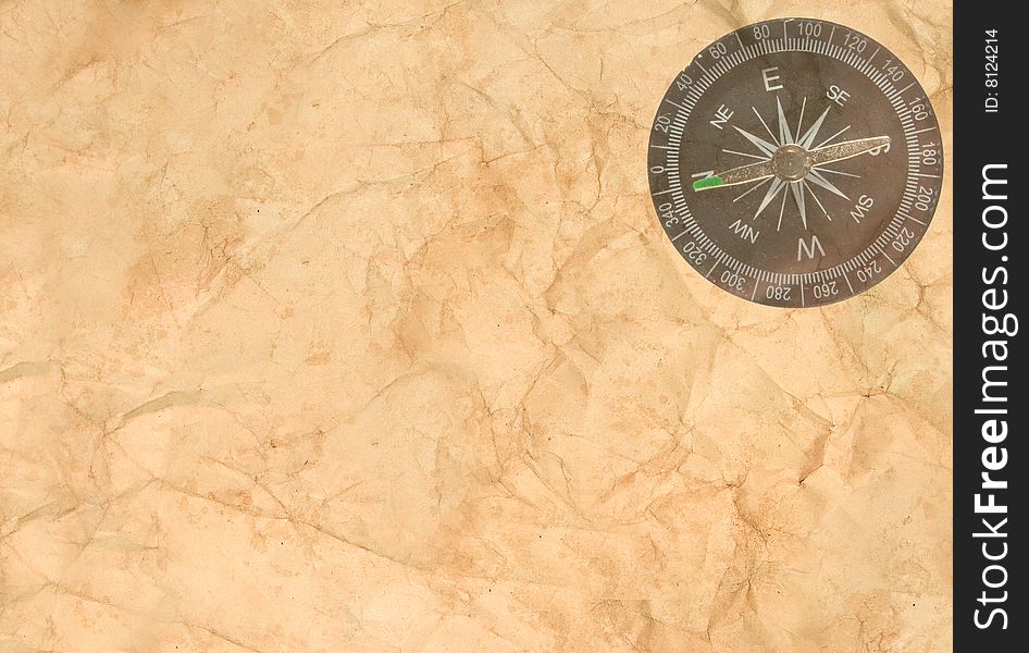Old crumpled paper with a transparent compass in the corner. Old crumpled paper with a transparent compass in the corner