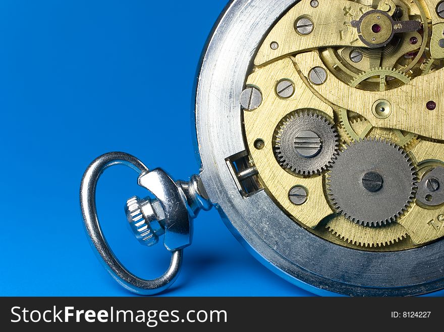 Closeup of old watch mechanism (on a bright blue background)