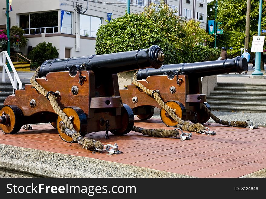 Two old iron and wood cannons on display at a public park. Two old iron and wood cannons on display at a public park