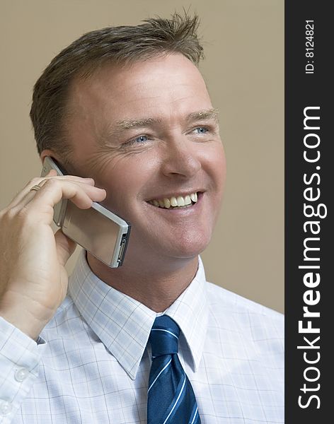 A happy businessman enjoys a friendly chat on his cellphone. A happy businessman enjoys a friendly chat on his cellphone.