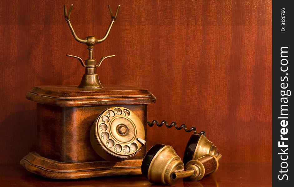 An antique telephone with the receiver left on hold. An antique telephone with the receiver left on hold