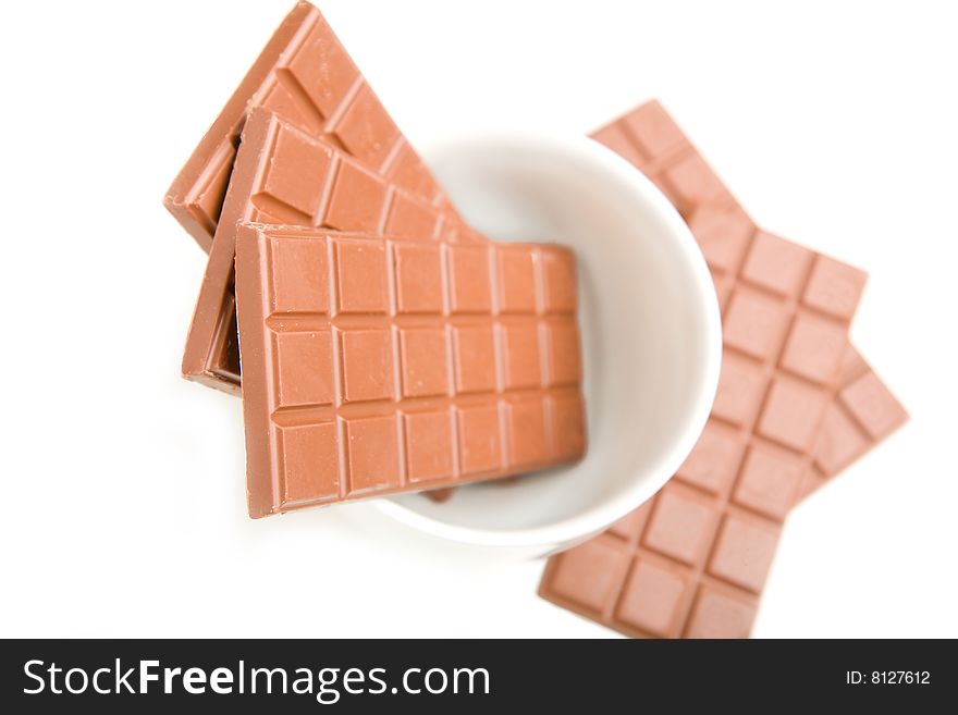 Rich milk chocolate bars in a large white cup.