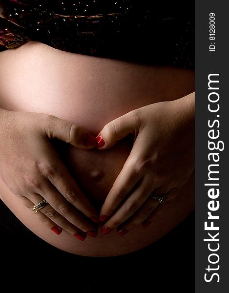 Side view of pregnant woman holding her tummy on an isolated background