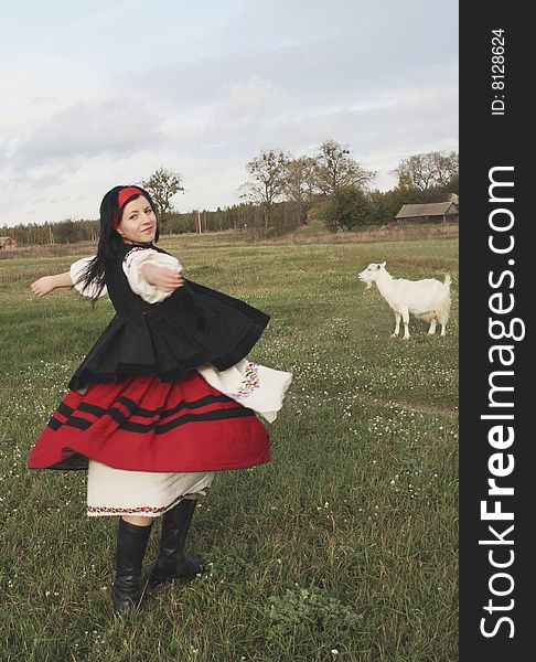 Village girl in Ukrainian clothes with goat