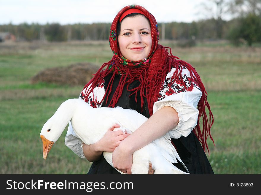 Village girl keeping a goose in Ukrainian clothes