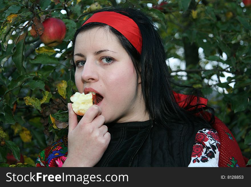 Village girl eating an aple in Ukrainian clothes eating an apple