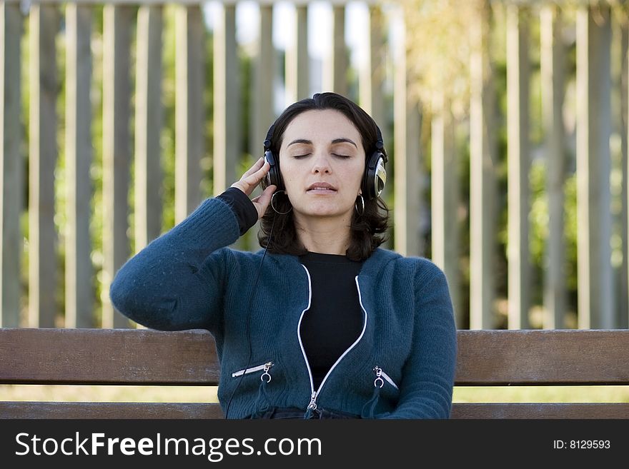 Young woman listens to music in park. Young woman listens to music in park
