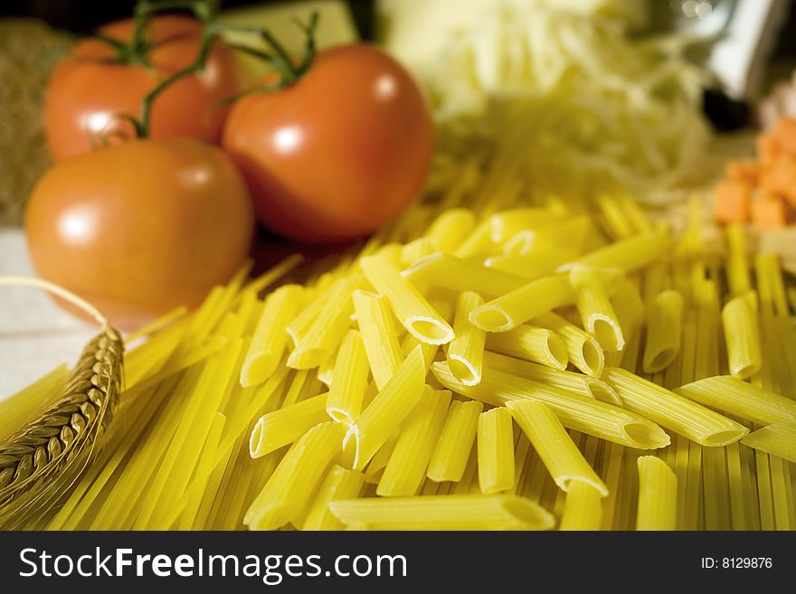 AA lot of raw ready for cooking macaroni on a table top with fresh tomatoes