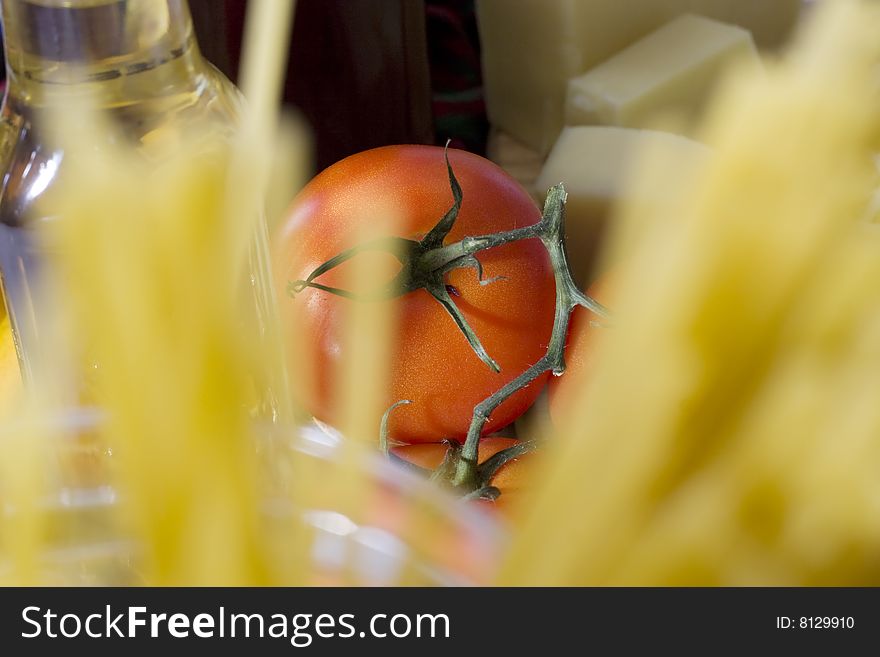 Tomato behind raw spaghetti in glass container
