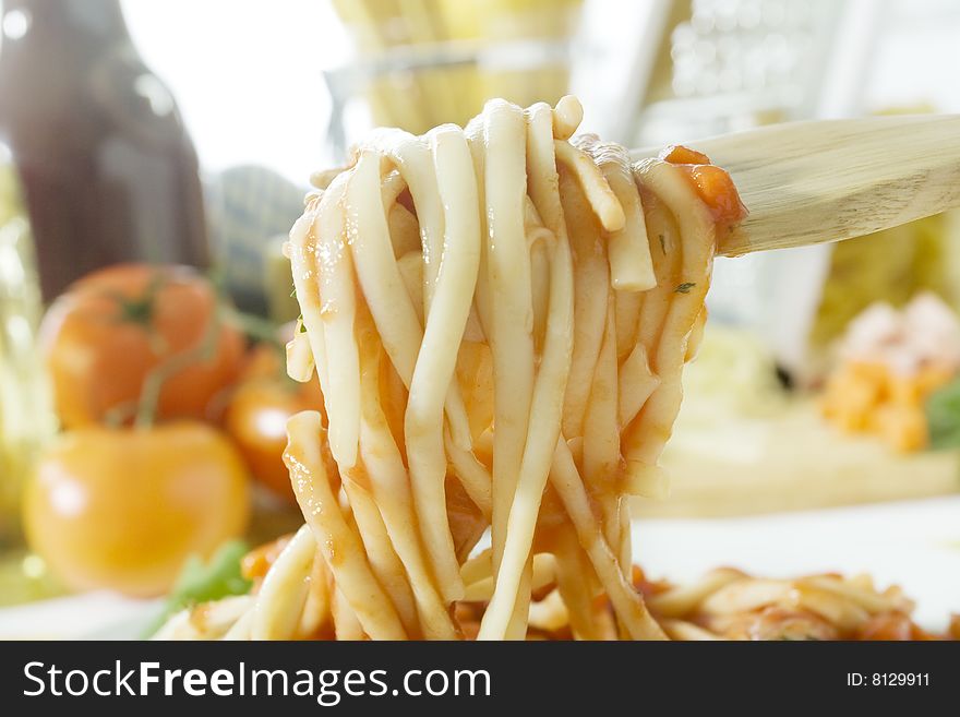 Close up shot wooden fork with freshly cooked spaghetti. Close up shot wooden fork with freshly cooked spaghetti