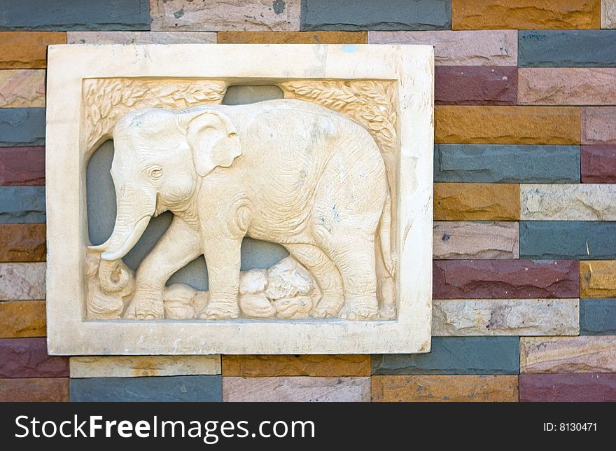 Marble elephant on the brick wall