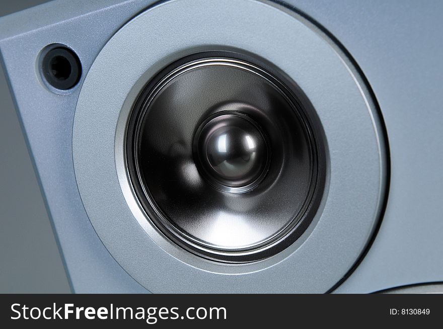 Close detail of an silver audio speaker. Close detail of an silver audio speaker