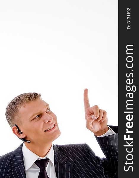 Young businessman pointing upwards against white background