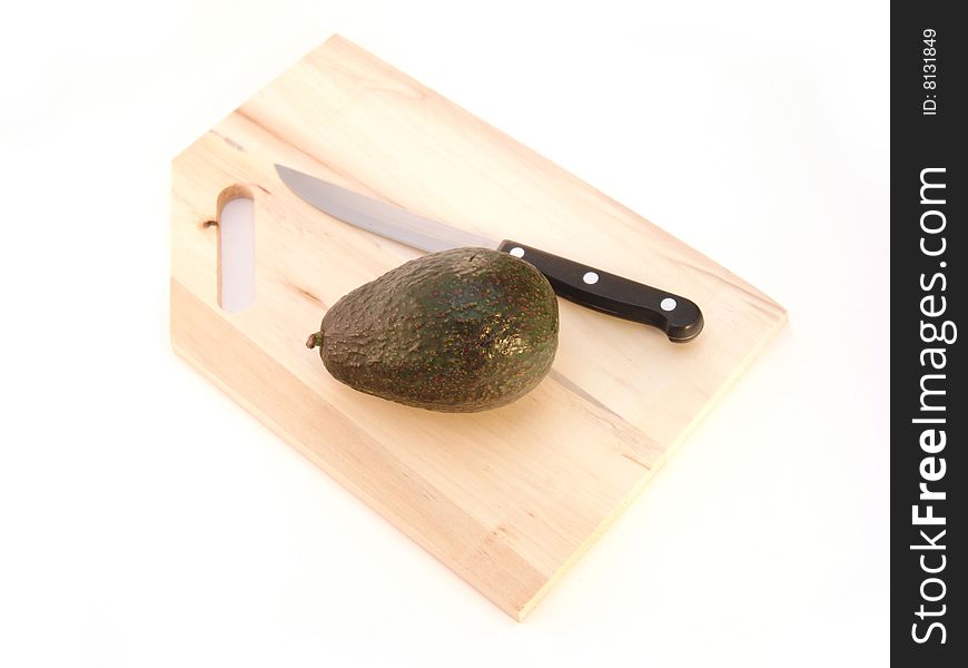 Avocado on cutting board with knife over white