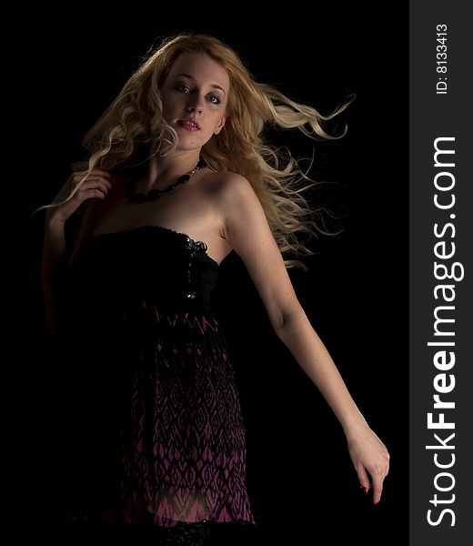 Beautiful blonde young lady in brown dress black background. Beautiful blonde young lady in brown dress black background