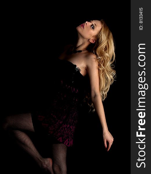 Beautiful blonde young lady in brown dress black background. Beautiful blonde young lady in brown dress black background