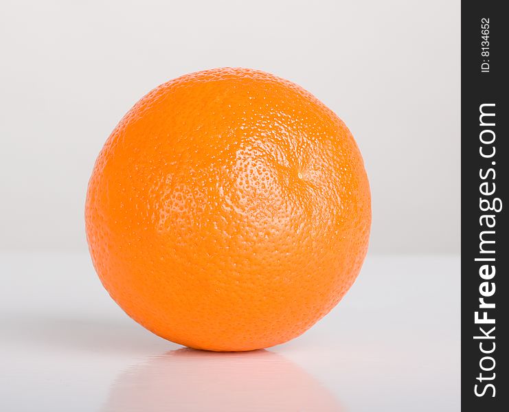 Orange on table with reflection, shot in studio