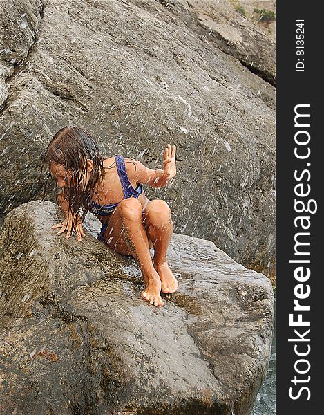 Girl in sunburnt on the rock