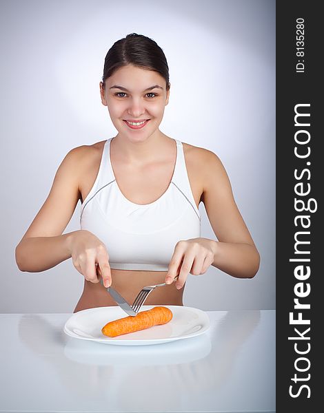 Woman cutting a carrot on a plate. Woman cutting a carrot on a plate