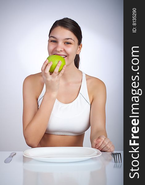 Happy woman eating a green apple smiling. Happy woman eating a green apple smiling