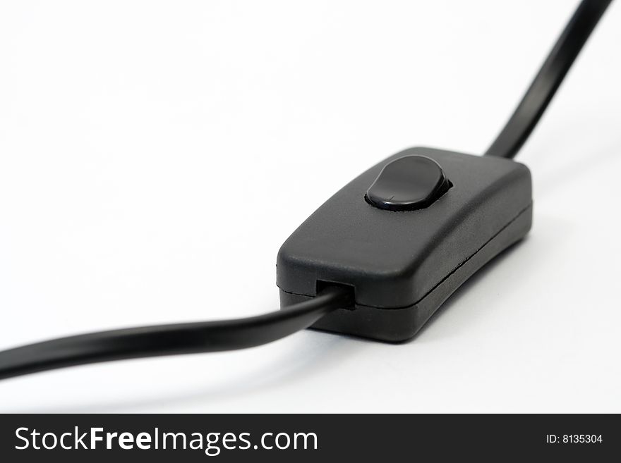 Black electric cable with switch lying on white background. Black electric cable with switch lying on white background