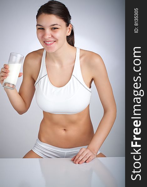 Woman drinking a glass of milk smiling. Woman drinking a glass of milk smiling