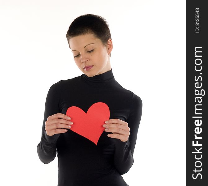 A short hair slim brunette in black dress holds a red paper heart. A short hair slim brunette in black dress holds a red paper heart