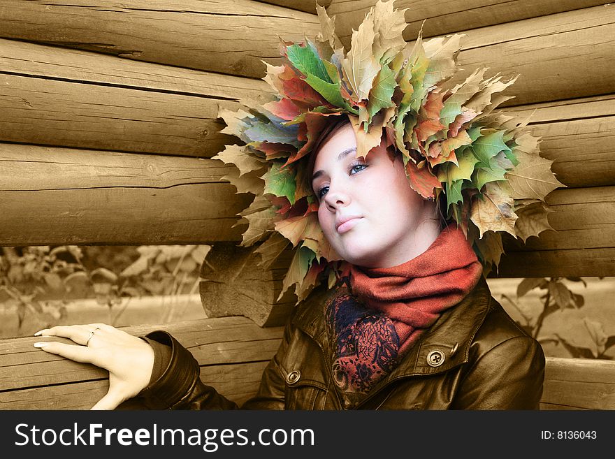 Girl with autumn yellow leaves at wood background. Girl with autumn yellow leaves at wood background