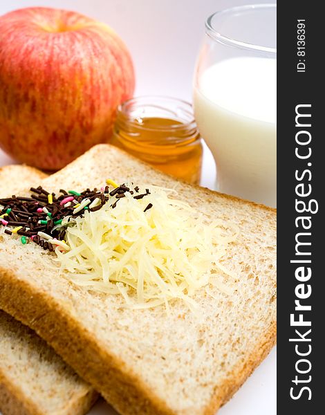 Meal ingredient for healthy and easy breakfast: wheat bread, fruit jam, chocolate sprinkles, a glass of milk and apple. Meal ingredient for healthy and easy breakfast: wheat bread, fruit jam, chocolate sprinkles, a glass of milk and apple