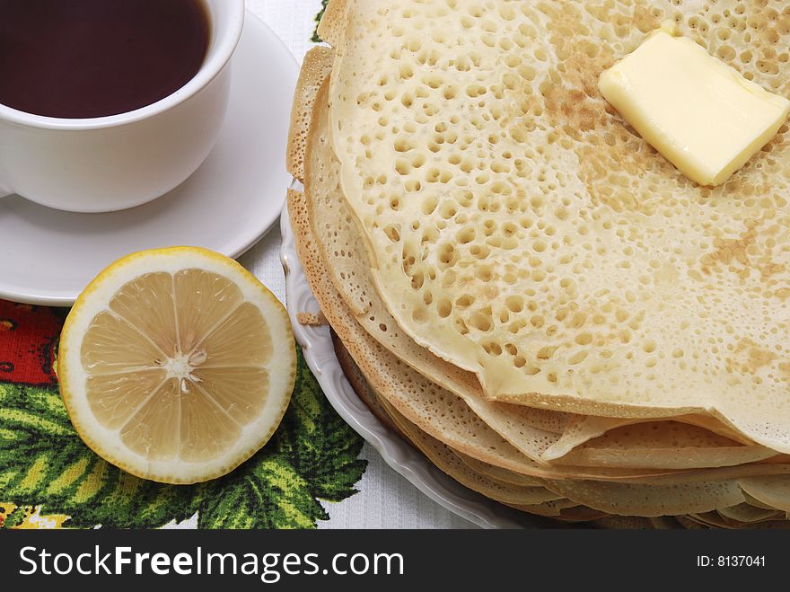 Pile fresh pancake with butter and tea. Pile fresh pancake with butter and tea