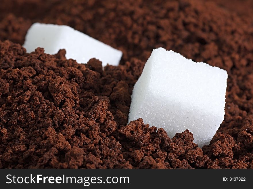 Piece of sugar on a background the ground coffee. Piece of sugar on a background the ground coffee.