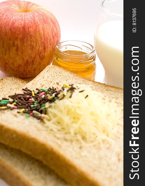 Meal ingredient for healthy & easy breakfast: wheat bread, fruit jam, chocolate sprinkles, a glass of milk and apple. Meal ingredient for healthy & easy breakfast: wheat bread, fruit jam, chocolate sprinkles, a glass of milk and apple