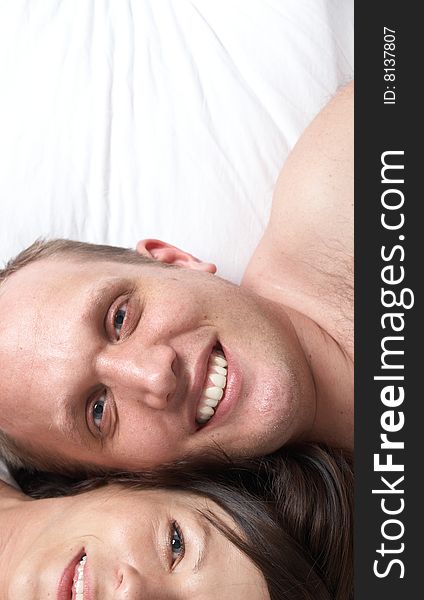 Portrait of young happy loving couple in their bedroom. Portrait of young happy loving couple in their bedroom.