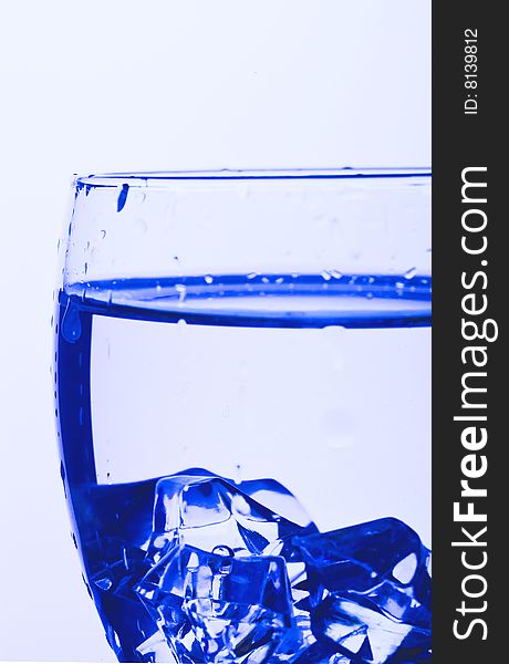 Blue Glass with Splashing water. Coolness Drink