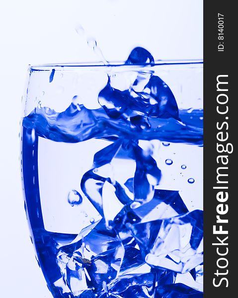 Blue Glass with Splashing water. Coolness Drink