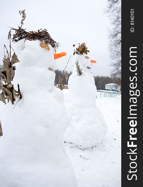 Two white snowmen in park. Two white snowmen in park