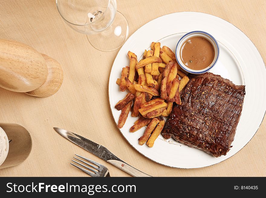 Steak and frite on a plate with focus on the steak. Steak and frite on a plate with focus on the steak