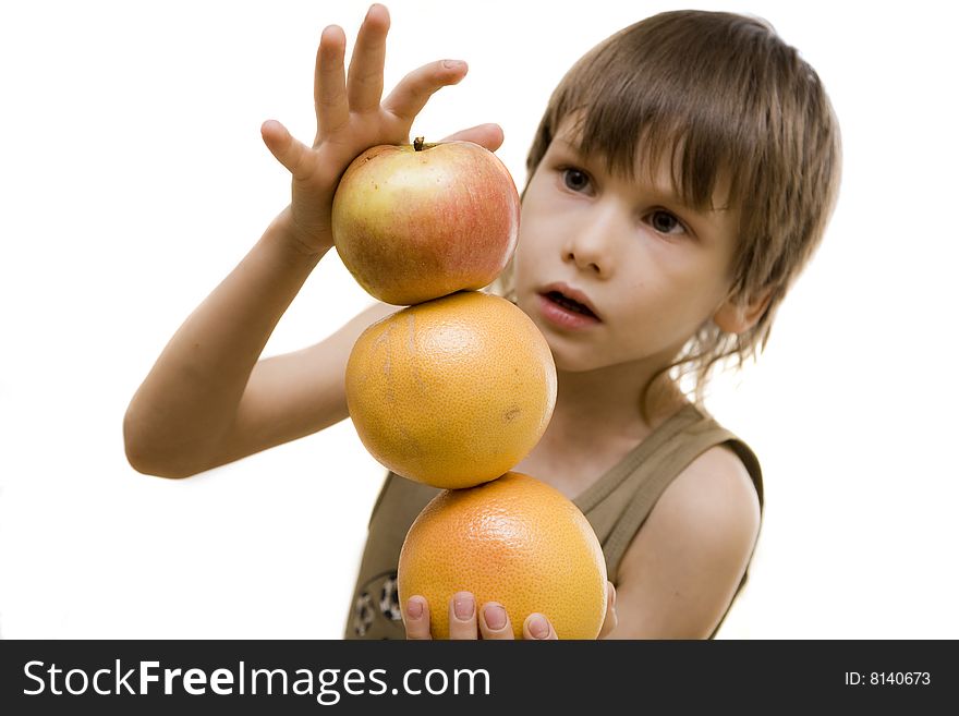 Young boy hold an apple and two grapefruits. Young boy hold an apple and two grapefruits