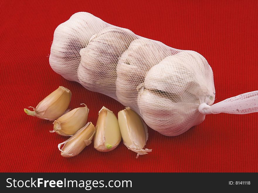 Garlic in the package with the slices on a red background