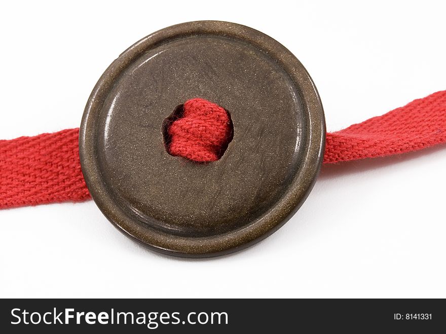 Brown button with a red ribbon on white background. Brown button with a red ribbon on white background